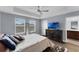Bright main bedroom featuring tray ceiling, wood floors, large windows and ensuite bathroom at 8968 Hildreth Ave, Orlando, FL 32832