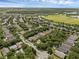 Expansive aerial view of a residential area with abundant trees and a green field and pond at 9031 Stonebury Way, Orlando, FL 32832