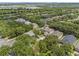 An aerial view of a neighborhood with mature trees, bodies of water and some homes with solar panels at 9031 Stonebury Way, Orlando, FL 32832