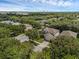 Aerial view of a home in a neighborhood with mature trees and view of lake at 9031 Stonebury Way, Orlando, FL 32832