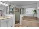 Bright bathroom features a tiled shower, soaking tub, double sinks, and natural light at 9031 Stonebury Way, Orlando, FL 32832
