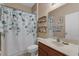 Stylish bathroom with a vanity, decorative shower curtain and open shelving at 9031 Stonebury Way, Orlando, FL 32832