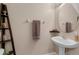 Charming half bathroom features pedestal sink, decorative shelving and a towel rack at 9031 Stonebury Way, Orlando, FL 32832