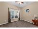 Cozy bedroom with neutral walls, a ceiling fan, and a window overlooking the pool at 9031 Stonebury Way, Orlando, FL 32832
