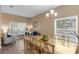 Bright dining room featuring a large glass table, chandelier, and sun-lit windows at 9031 Stonebury Way, Orlando, FL 32832