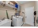 Bright laundry room with modern washer and dryer, utility sink, and ample shelving at 9031 Stonebury Way, Orlando, FL 32832