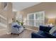 Bright living room featuring a patterned chair, tile floors, and double door entrance at 9031 Stonebury Way, Orlando, FL 32832