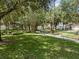 Neighborhood park featuring mature trees, green grass, walking path, and a shaded bench at 9031 Stonebury Way, Orlando, FL 32832