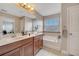 This bathroom features double sinks with wood cabinets and a bathtub at 9997 Town Lake Dr, Orlando, FL 32832