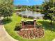 Ravinia at East Park sign displayed with colorful flowerbeds and a relaxing pond with a fountain feature at 9997 Town Lake Dr, Orlando, FL 32832