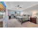 This main bedroom features carpet, a ceiling fan, a small desk and tv at 9997 Town Lake Dr, Orlando, FL 32832