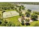 Aerial view of tennis courts and playground near a lake and homes at 9997 Town Lake Dr, Orlando, FL 32832
