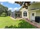 A well-maintained backyard features a screened-in pool area, lush lawn, and a charming garden with comfortable seating at 10254 Hart Branch Cir, Orlando, FL 32832