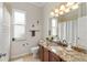 Well-lit bathroom featuring a granite countertop, window, and shower with a decorative curtain at 10254 Hart Branch Cir, Orlando, FL 32832