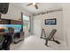 Bedroom featuring a ceiling fan, a desk with blue lighting, and fitness equipment at 10254 Hart Branch Cir, Orlando, FL 32832
