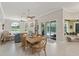 Dining area leading to living room and outdoor patio/pool with a view of fireplace and arched windows at 10254 Hart Branch Cir, Orlando, FL 32832