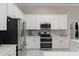 Modern kitchen with white cabinetry, stainless steel appliances, and stylish backsplash; bright and spacious at 10254 Hart Branch Cir, Orlando, FL 32832