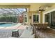 Enclosed patio with dining set, comfortable seating, and a view of the inviting swimming pool at 10254 Hart Branch Cir, Orlando, FL 32832