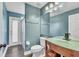 Updated bathroom featuring shower, blue walls, and glass bowl sink at 1031 Seneca Trl, St Cloud, FL 34772