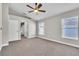Spacious bedroom featuring neutral walls, carpet, ceiling fan, and an arched doorway at 1031 Seneca Trl, St Cloud, FL 34772