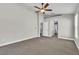 Expansive bedroom with neutral walls, carpet, ceiling fan, and doorway leading to bathroom at 1031 Seneca Trl, St Cloud, FL 34772