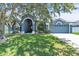 Charming single-story home featuring a manicured lawn, arched entryway and an attached two-car garage at 1031 Seneca Trl, St Cloud, FL 34772
