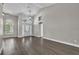 Open-concept living room with high ceilings, arched windows, stylish light fixture, and elegant hardwood flooring at 1031 Seneca Trl, St Cloud, FL 34772