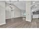 Expansive living room with sleek hardwood flooring, a modern light fixture, and seamless access to the kitchen at 1031 Seneca Trl, St Cloud, FL 34772
