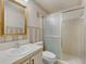 A full bathroom featuring a large mirror, patterned wallpaper, and a sliding glass shower door at 1032 Calanda Ave # 1032, Orlando, FL 32807