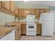 Well-lit kitchen with light wood cabinetry, essential appliances, and a functional layout at 1032 Calanda Ave # 1032, Orlando, FL 32807