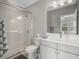 This bathroom features a glass-enclosed shower, white subway tile, and a gray vanity at 1034 Huntspoint St, Winter Garden, FL 34787