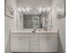 This spacious bathroom features a double vanity with white cabinets and quartz countertops at 1034 Huntspoint St, Winter Garden, FL 34787