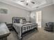 This carpeted bedroom features a ceiling fan, an iron bed frame, and a connected bathroom at 1034 Huntspoint St, Winter Garden, FL 34787