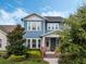 Charming two-story home with a blue exterior, white trim, and a welcoming front porch with brick accents at 1034 Huntspoint St, Winter Garden, FL 34787