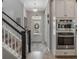 Hallway featuring a staircase, appliances, light-colored hardwood floors, and a front door with sidelight windows at 1034 Huntspoint St, Winter Garden, FL 34787