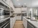 Modern kitchen with stainless steel appliances, white cabinets, marble countertops, and hardwood flooring at 1034 Huntspoint St, Winter Garden, FL 34787