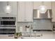 Bright kitchen with stainless steel appliances, tile backsplash, and pendant lighting at 1034 Huntspoint St, Winter Garden, FL 34787