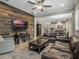 Spacious living room with a leather sofa, wood accent wall, and an open layout to the kitchen and dining area at 1034 Huntspoint St, Winter Garden, FL 34787
