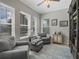 Bright sitting room with large windows, comfortable seating, neutral decor, and light-colored hardwood floors at 1034 Huntspoint St, Winter Garden, FL 34787