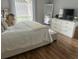 Serene bedroom with soft bedding, wood floors, a dresser, and a large mirror, creating a peaceful retreat at 1034 Villa Ln # 18, Apopka, FL 32712
