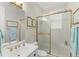 A well-lit bathroom showcases a glass-enclosed shower, white vanity, and gold-toned fixtures at 10915 Emerald Chase Dr, Orlando, FL 32836
