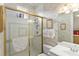 Bathroom featuring shower with gold trim, tile walls, and framed art on a decorated wall at 10915 Emerald Chase Dr, Orlando, FL 32836