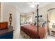 Bright bedroom featuring a decorative four-poster bed, sitting nook and neutral walls at 10915 Emerald Chase Dr, Orlando, FL 32836