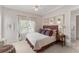 Cozy bedroom featuring a plush bed, window with custom curtains and a view to the attached bathroom at 10915 Emerald Chase Dr, Orlando, FL 32836