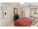 Bright bedroom with a decorative four-poster bed, sitting nook, and a view to the hallway at 10915 Emerald Chase Dr, Orlando, FL 32836