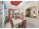 Elegant dining room featuring a coffered ceiling, stylish decor, and seating for ten at 10915 Emerald Chase Dr, Orlando, FL 32836