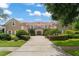 Inviting, two-story house with a red tile roof, manicured shrubs and a brick driveway at 10915 Emerald Chase Dr, Orlando, FL 32836
