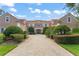 Grand residence featuring a tile roof, a paved driveway, and manicured landscaping for an impressive curb appeal at 10915 Emerald Chase Dr, Orlando, FL 32836