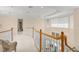 Elegant hallway with white carpet, wooden railing, recessed lighting, and a view into other rooms at 10915 Emerald Chase Dr, Orlando, FL 32836