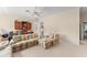 A neutral-painted living room with plush seating, large windows, and a ceiling fan at 10915 Emerald Chase Dr, Orlando, FL 32836